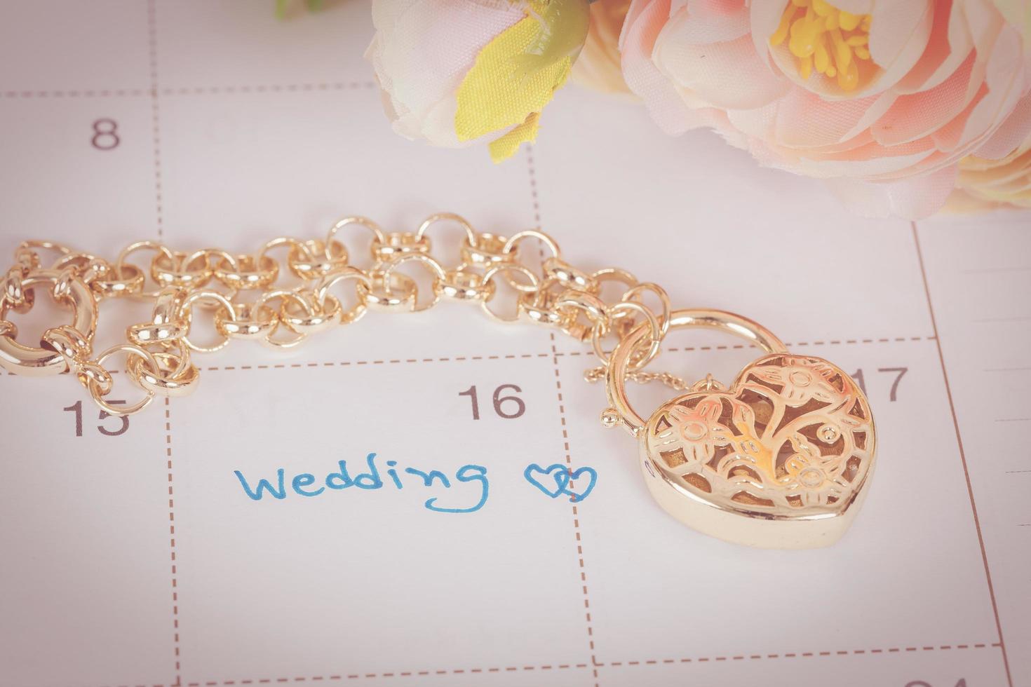 ord bröllop på kalender och guld armband med hjärta foto