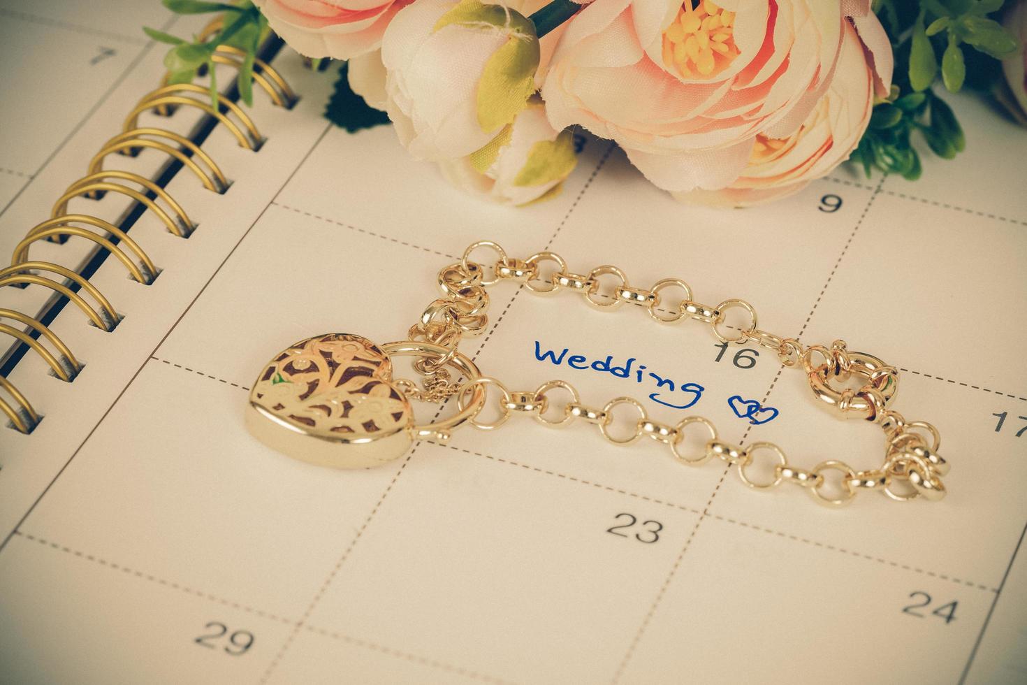 ord bröllop på kalender och guld armband med hjärta foto