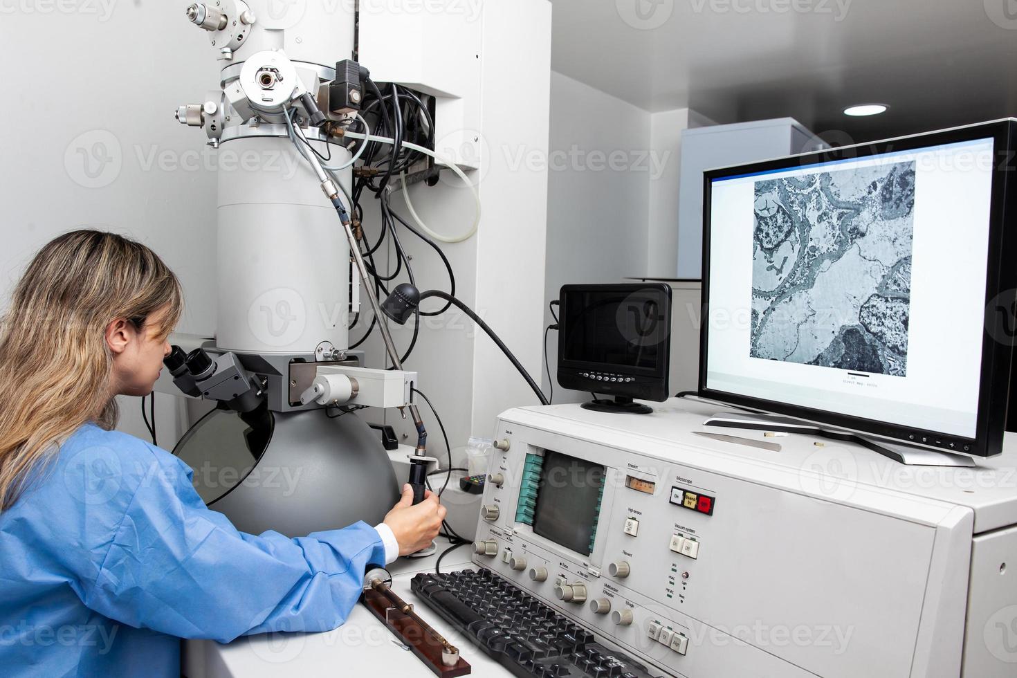 ung kvinna forskare arbetssätt på de laboratorium med ett elektron mikroskop foto