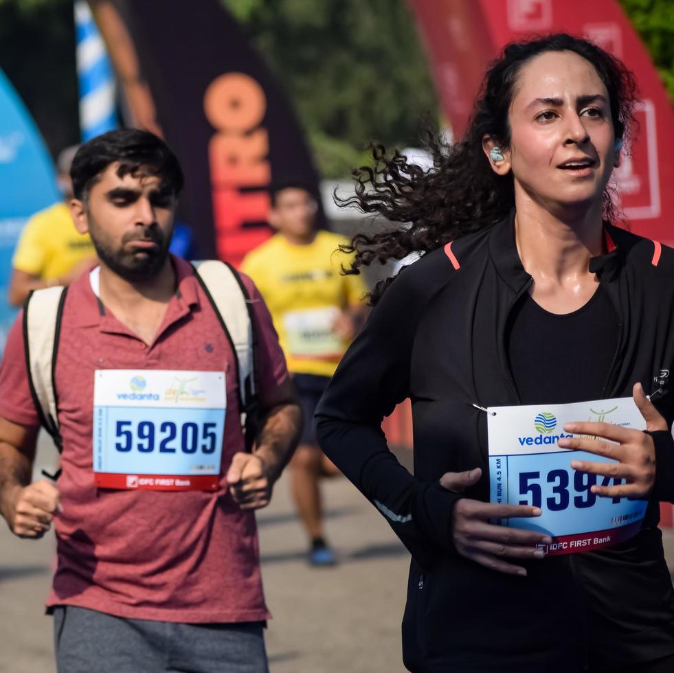 ny delhi, Indien - Mars 16 2023 - vedanta delhi halv maraton lopp efter covid i som maraton deltagarna handla om till korsa de Avsluta linje, delhi halv maraton 2022 foto