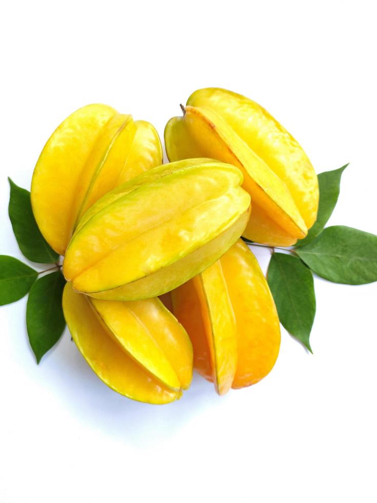 carambola också känd som stjärna frukt, är de frukt av averrhoa carambola, en arter av träd inföding till tropisk sydöst Asien. stjärna frukt med grön löv isolerat på en vit bakgrund foto