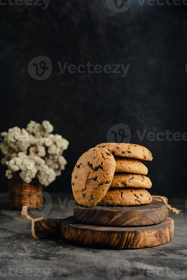 hemlagad choklad chip småkakor på rustik trä- underlägg och abstrakt bakgrund foto