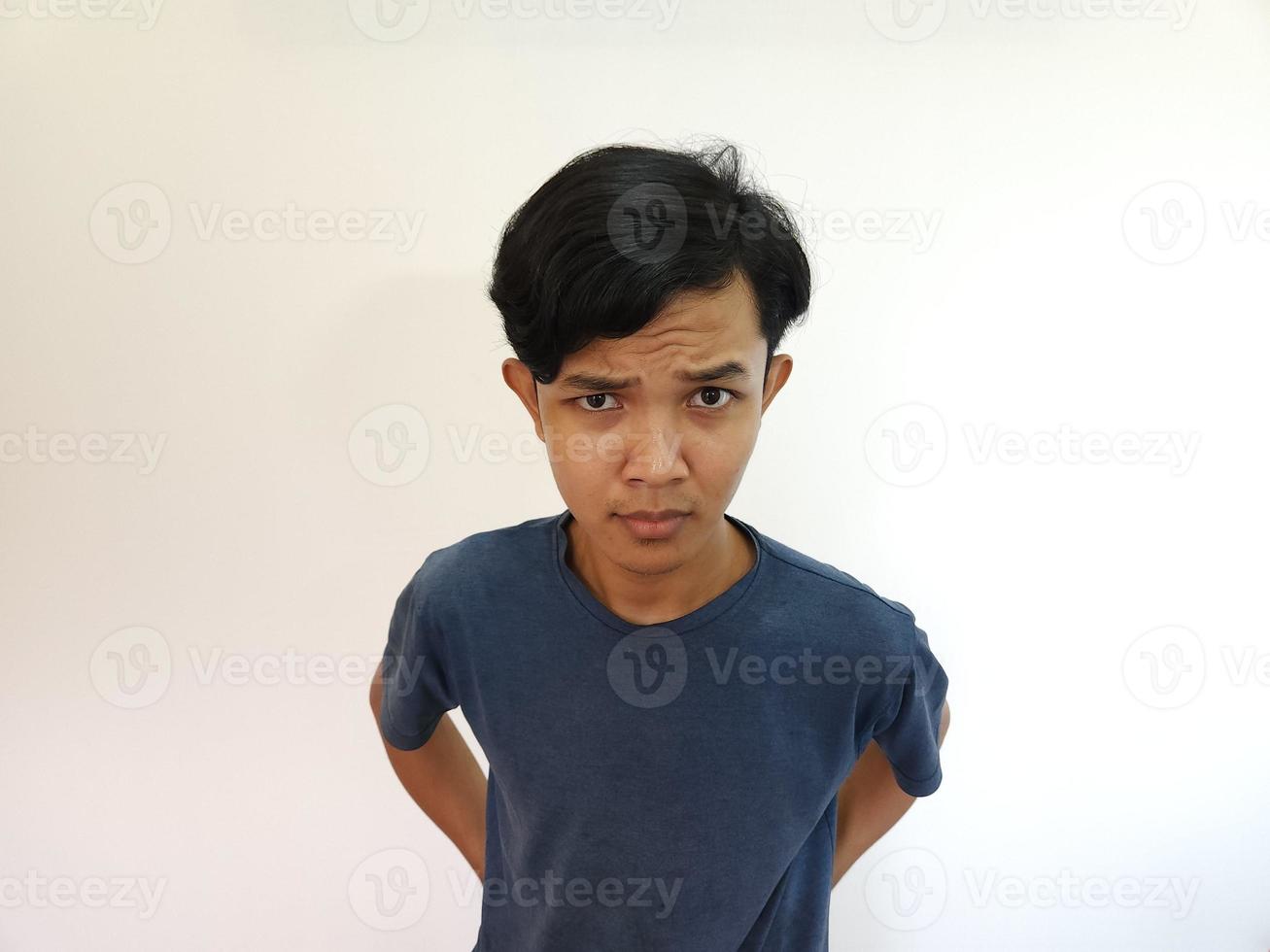 rolig uppenbar kikar asiatisk man i grå t-shirt isolerat på vit bakgrund foto