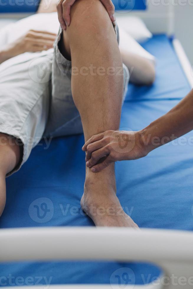 läkare eller fysioterapeut arbetssätt granskning behandla skadade ärm av idrottare manlig patient, stretching och träning, håller på med de rehabilitering terapi smärta i klinik. foto