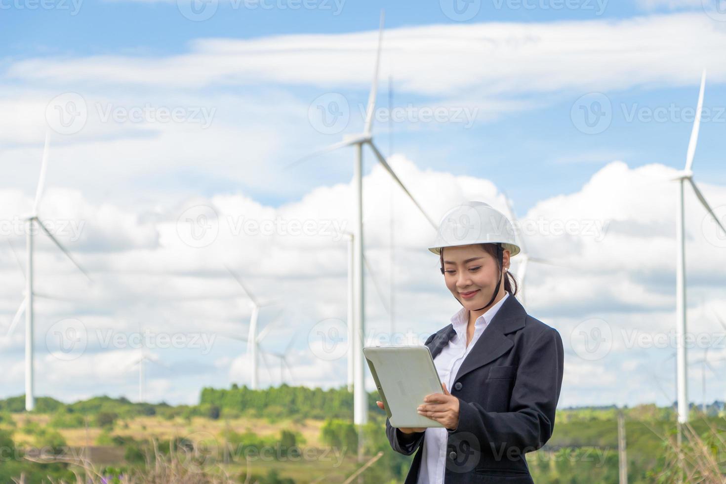 energi ingenjör kvinna arbetssätt på vind odla. asiatisk företag kvinna bär kostym innehav läsplatta och Urklipp med väderkvarn miljö förnybar energi. foto