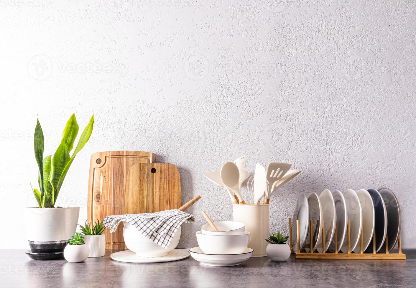 en uppsättning av olika kök redskap och verktyg, keramisk maträtter i ljus färger på en modern kök bänkskiva. främre se. en kopia Plats. foto