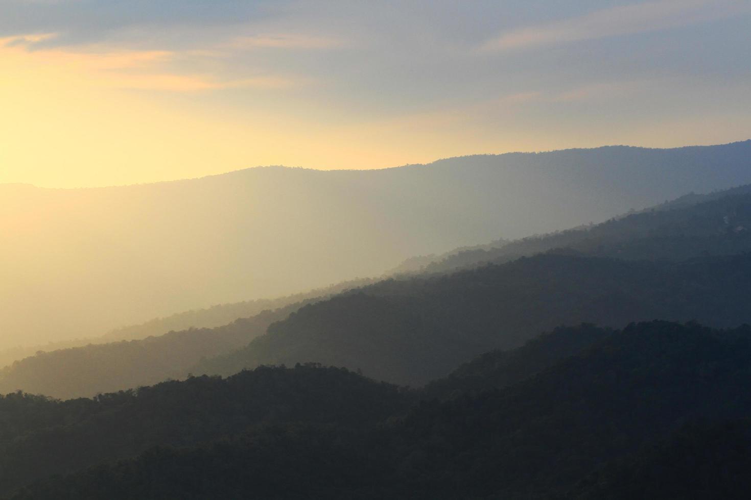 skön landskap skikten av berg och dimmig på kulle dal i gyllene skymning av solnedgång på thailand foto