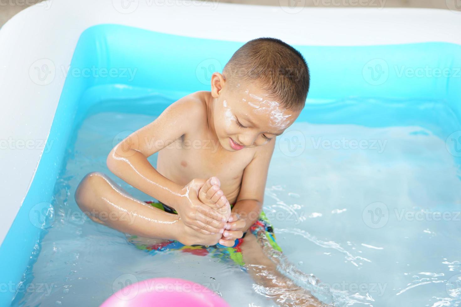 barn spelar i varm vatten Kolla på din fötter känna tycka om du är stepping på något. foto