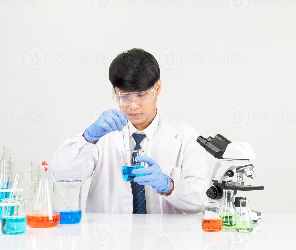 asiatisk man studerande forskare i reagens blandning laboratorium i en vetenskap forskning laboratorium med testa rör av olika storlekar. på de golv i laboratorium kemi labb vit bakgrund. foto