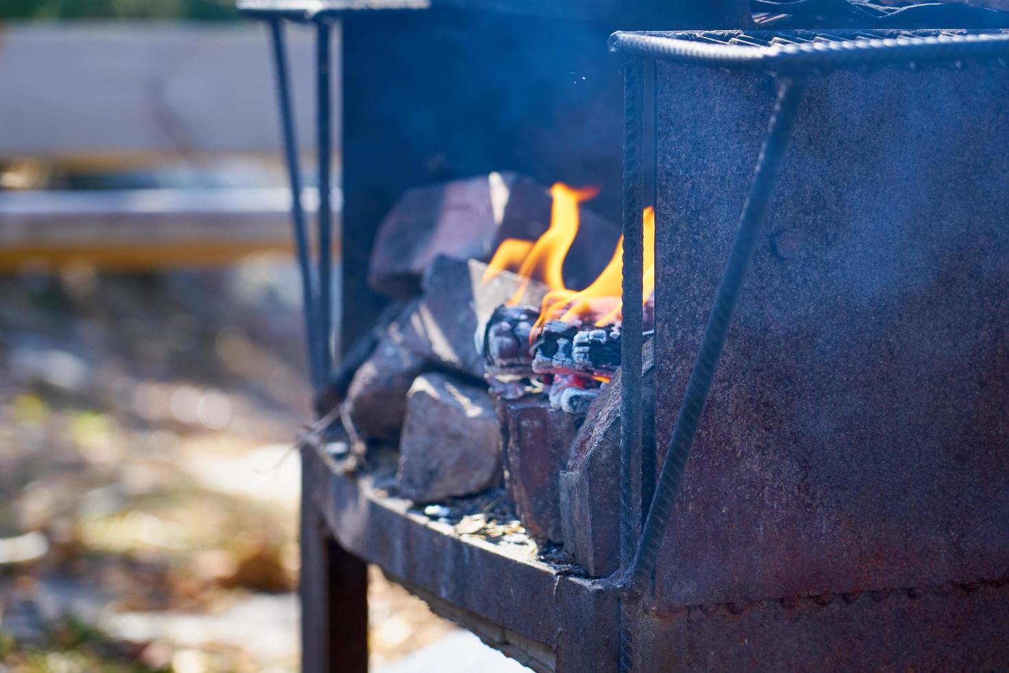 eld i en rostig vintage grill utomhus med suddig bakgrund foto