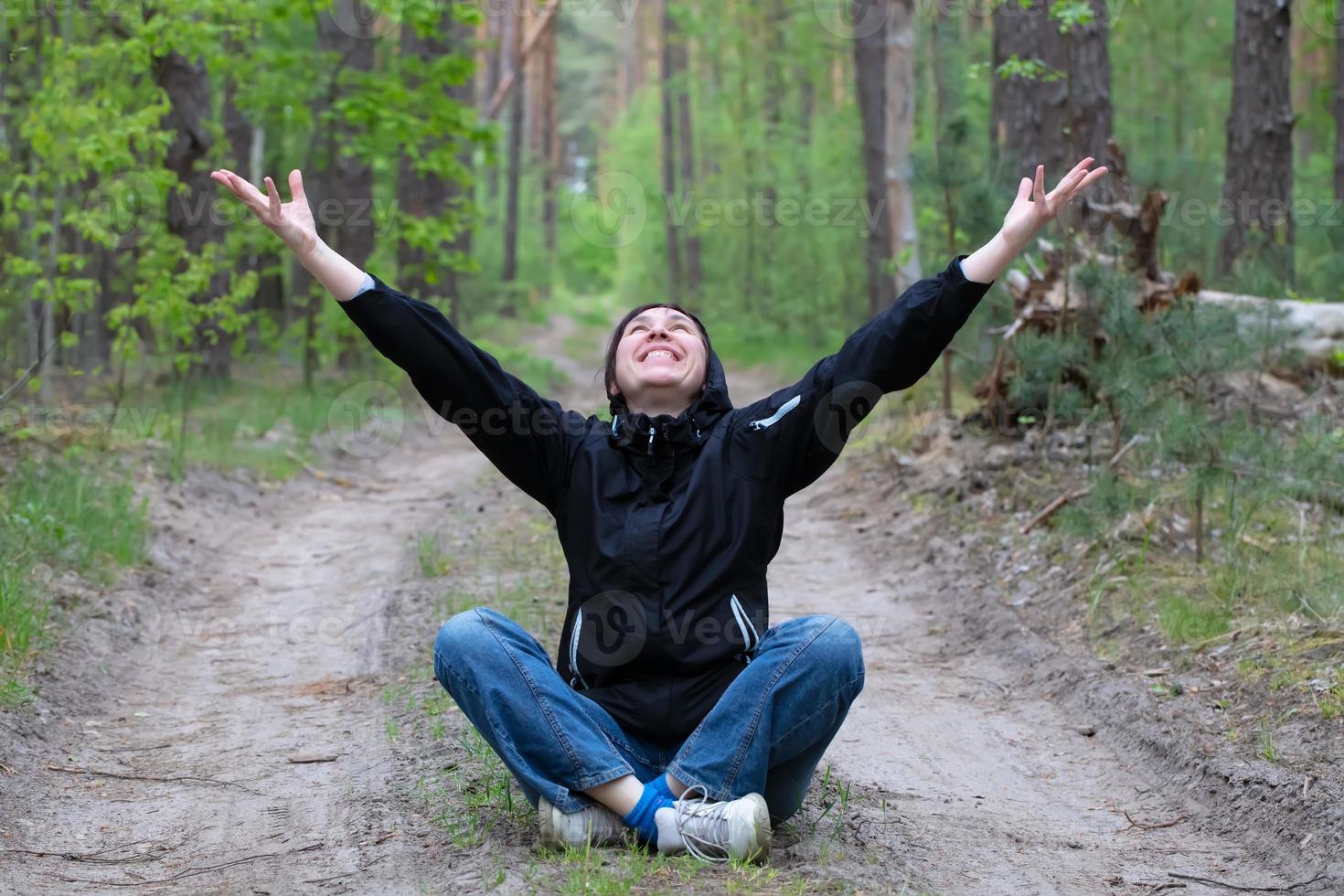 man i de skog. en medelålders kvinna sitter på en skog väg. foto