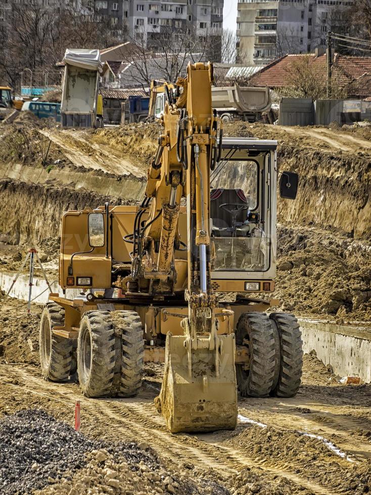 stor gul stannade grävmaskin på de konstruktion webbplats foto