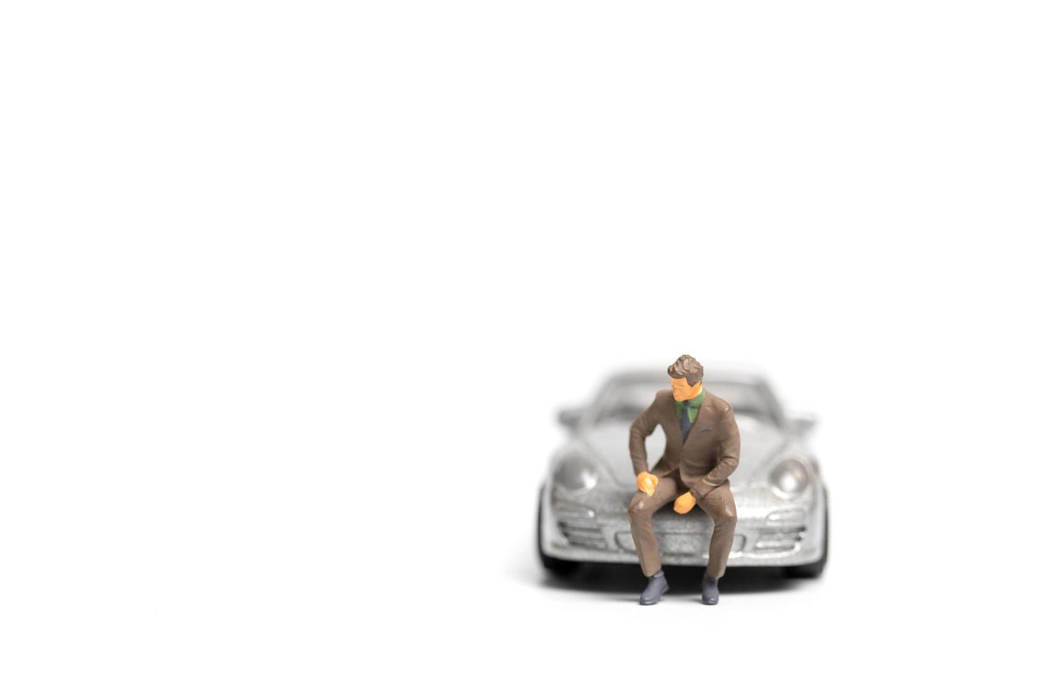 miniatyr människor, affärsman sitter på en bil och kopiera utrymme för text foto