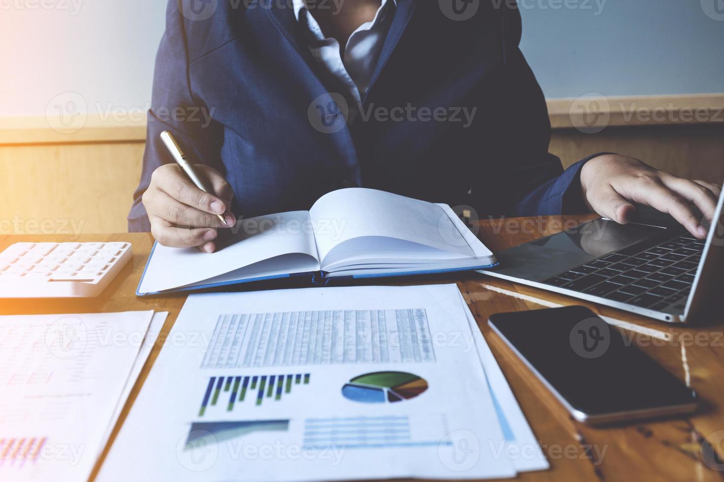 affärskvinna eller revisor händer som håller pennan med laptop, konto och sparande koncept. foto