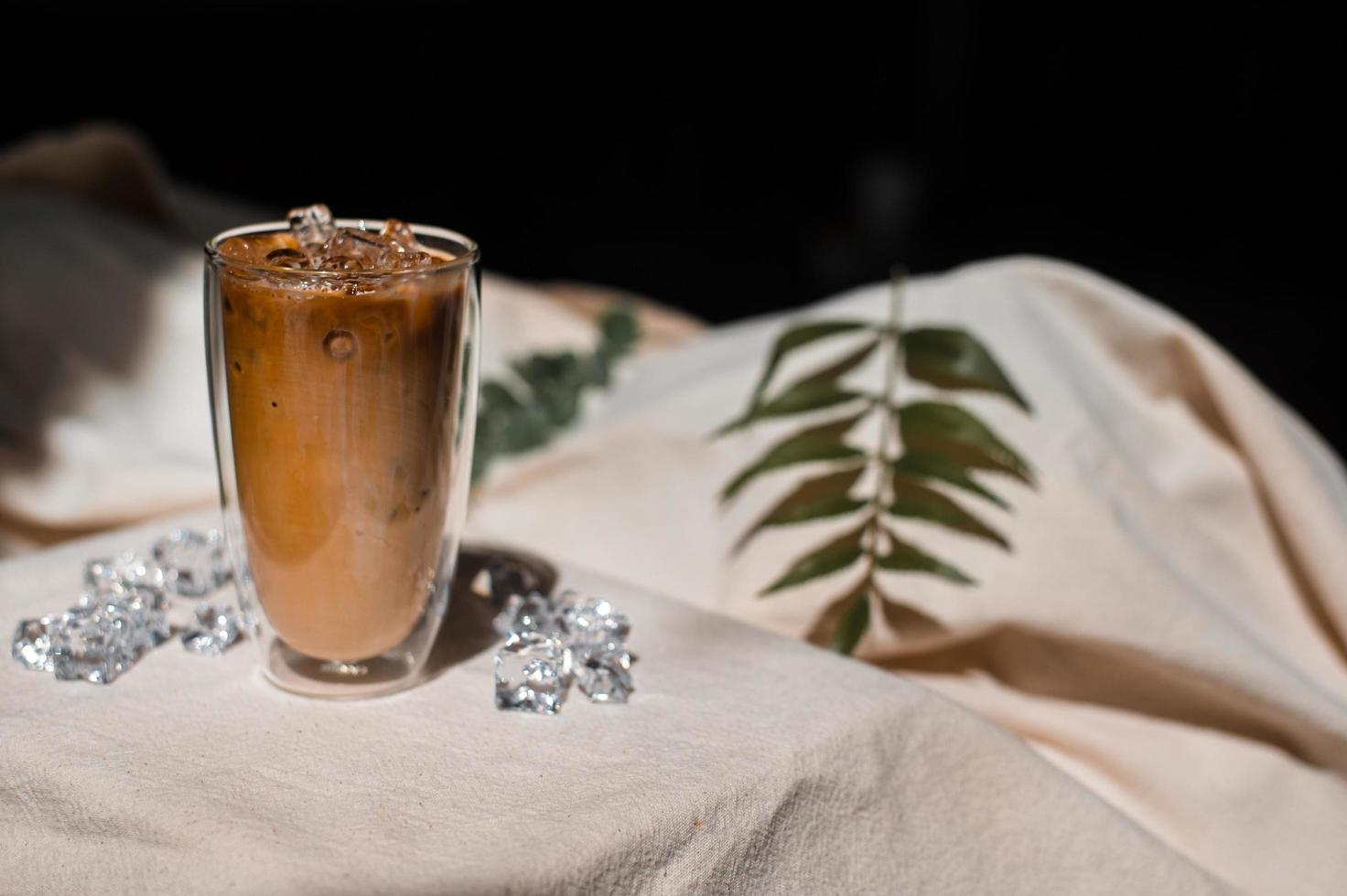 närbild glas iskaffe med mjölk på bordet foto