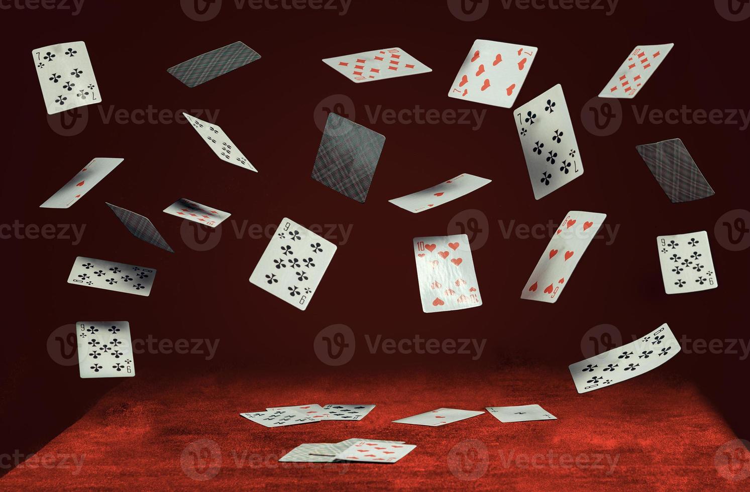 spelkort som flyger och faller på ett bord med en röd trasa foto