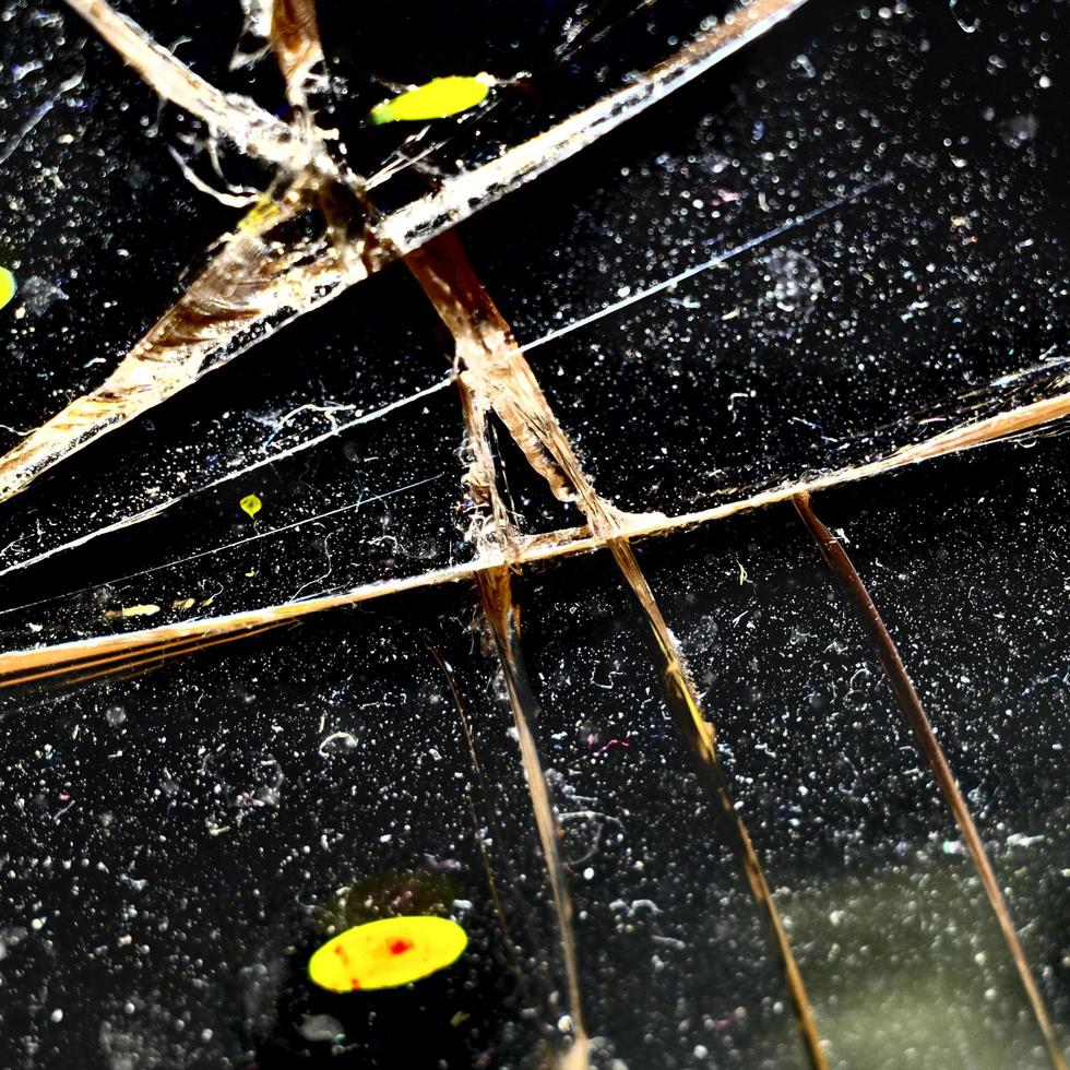 abstrakt krossat glas bakgrund med sprickor och fläckar av gul färg. foto