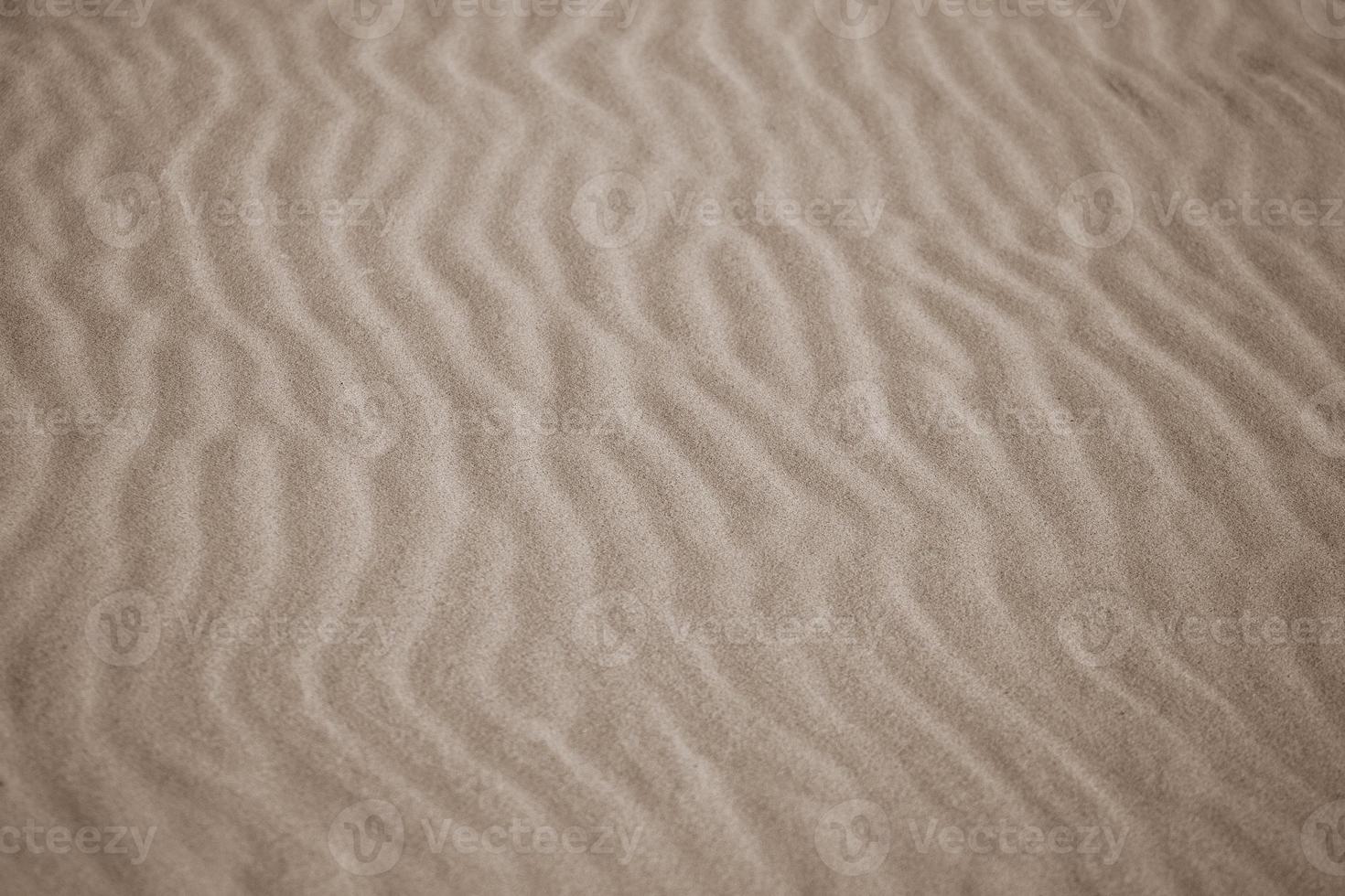 beige bakgrund med sand i de form av sand vågor foto