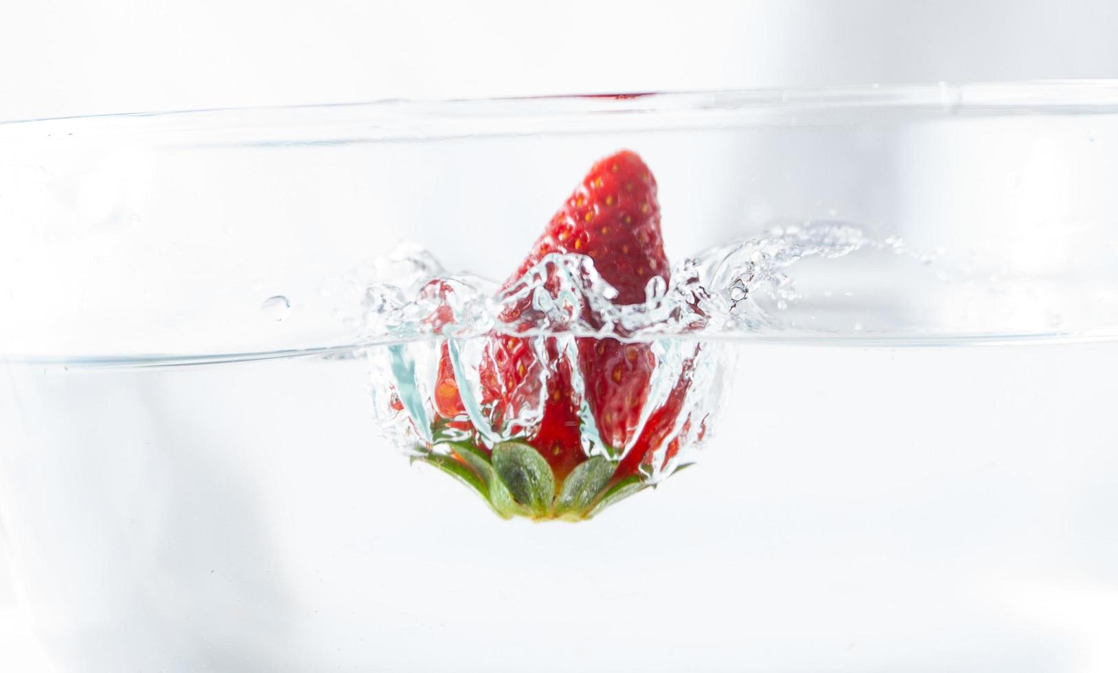 jordgubbsstänk i vatten foto