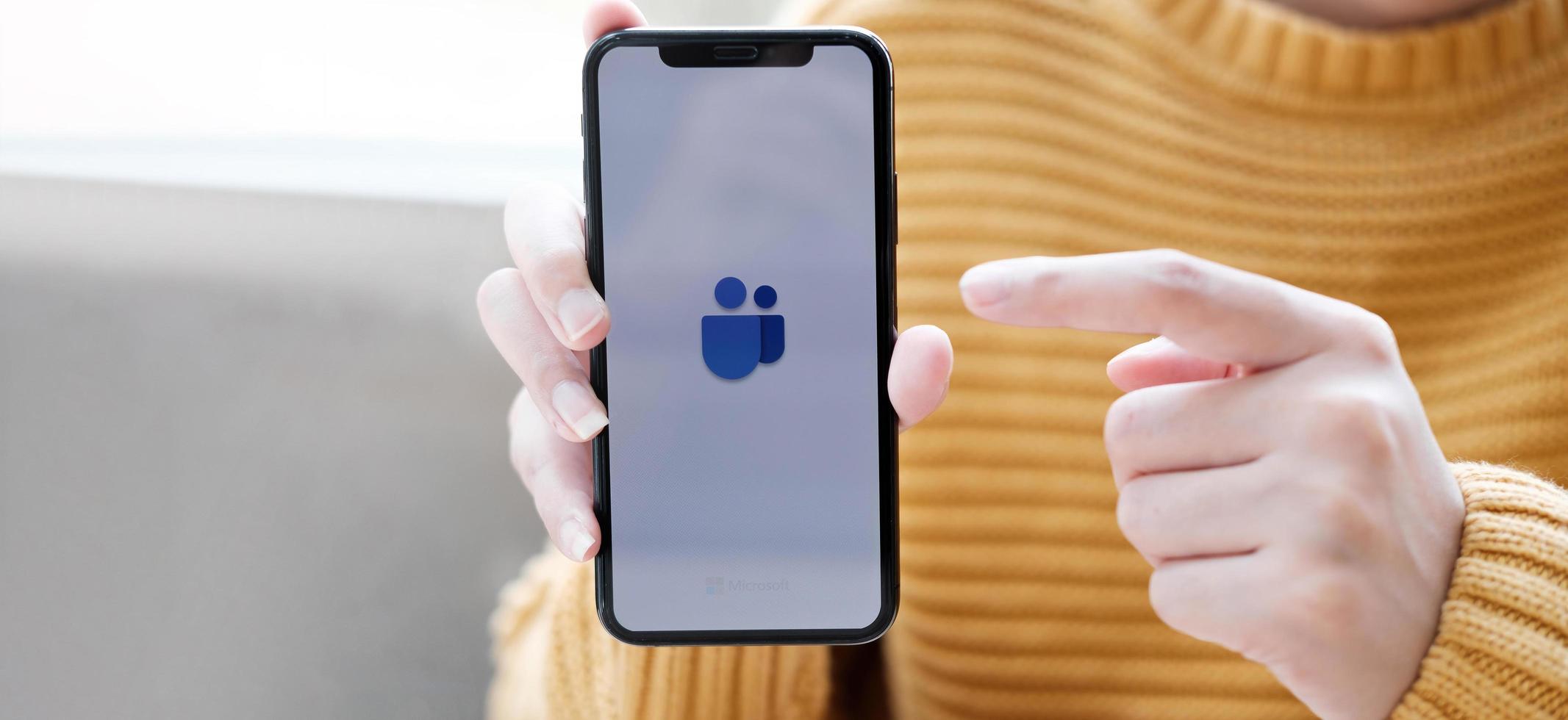 chaing mai, thailand, 11 apr 2021 - person som pekar på en telefon med Microsoft-team på den foto