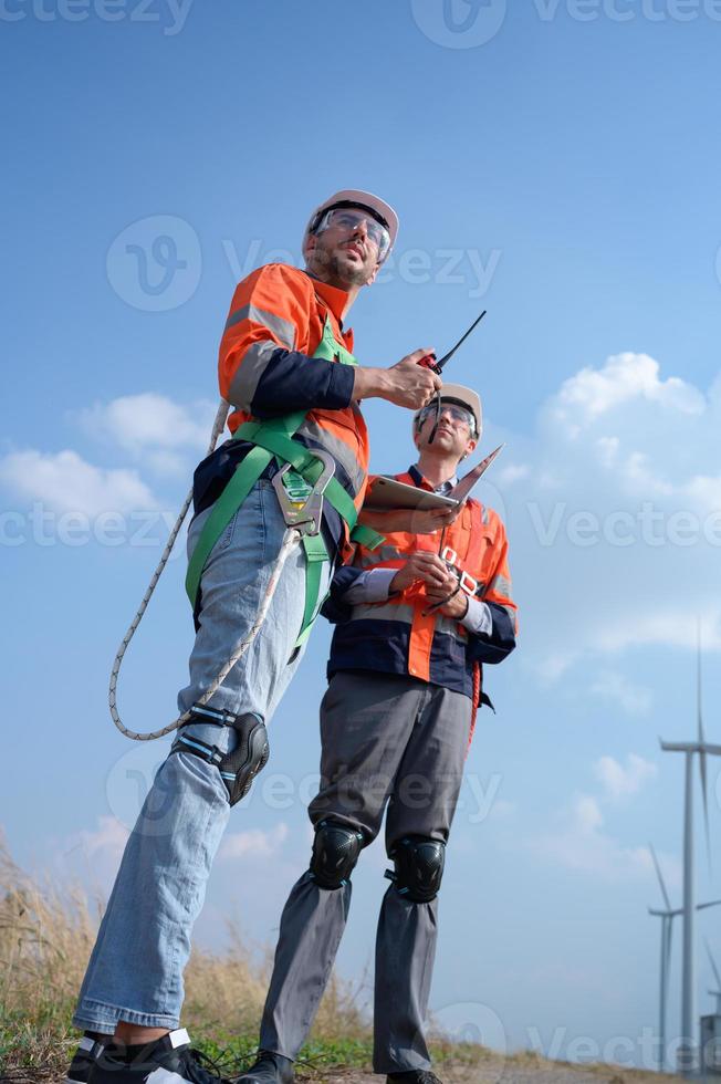 besiktningsman och ingenjör undersöka de effektivitet av gigantisk vind turbiner den där omvandla vind energi in i elektrisk energi den där är sedan Begagnade i dagligen liv. foto