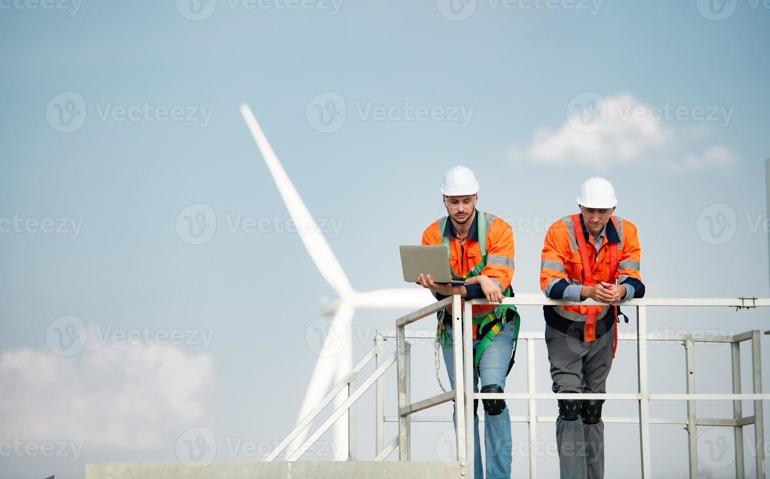 besiktningsman och ingenjör undersöka de effektivitet av gigantisk vind turbiner den där omvandla vind energi in i elektrisk energi den där är sedan Begagnade i dagligen liv. foto