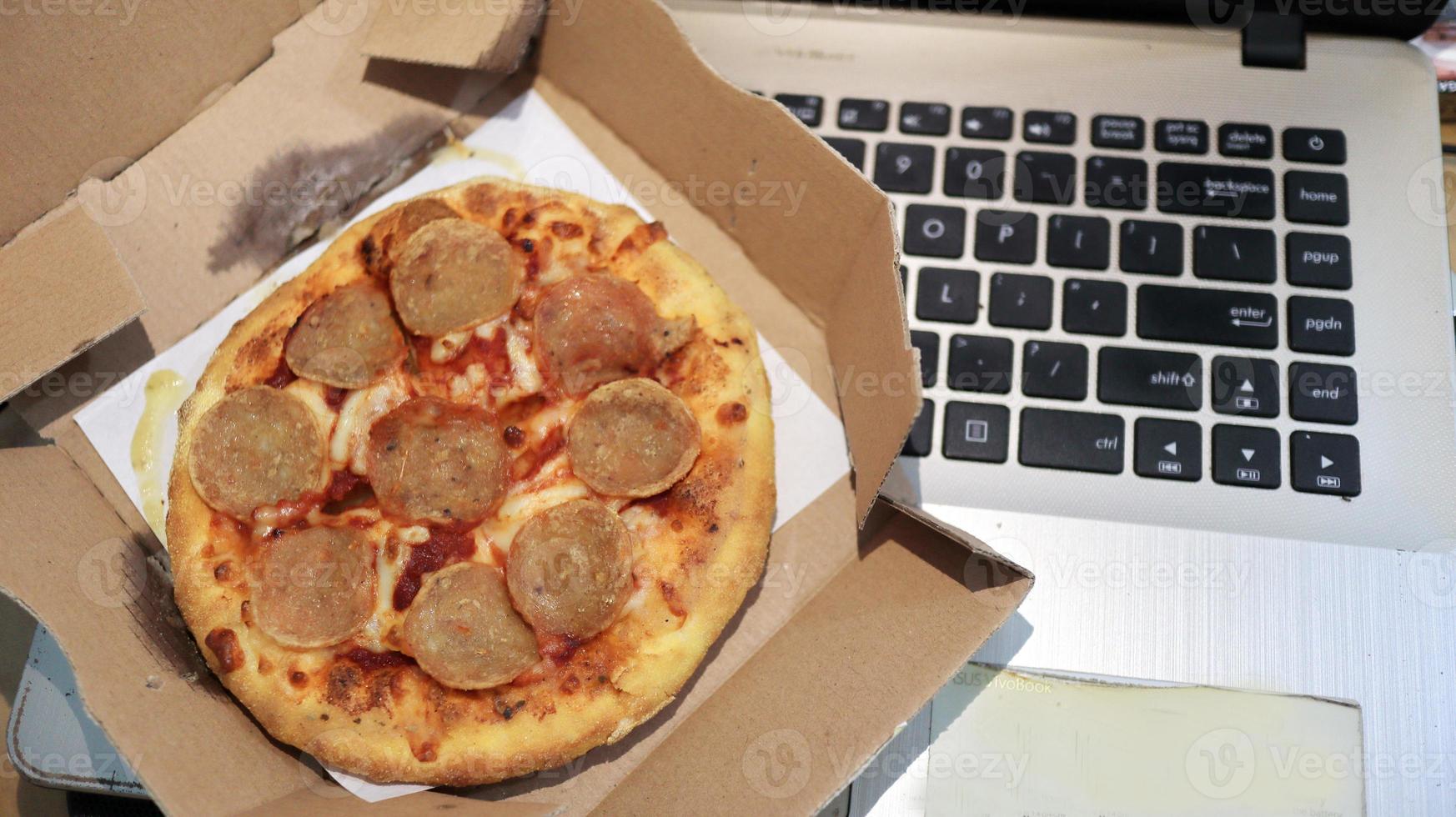 arbetar kontor med en välsmakande pizza foto