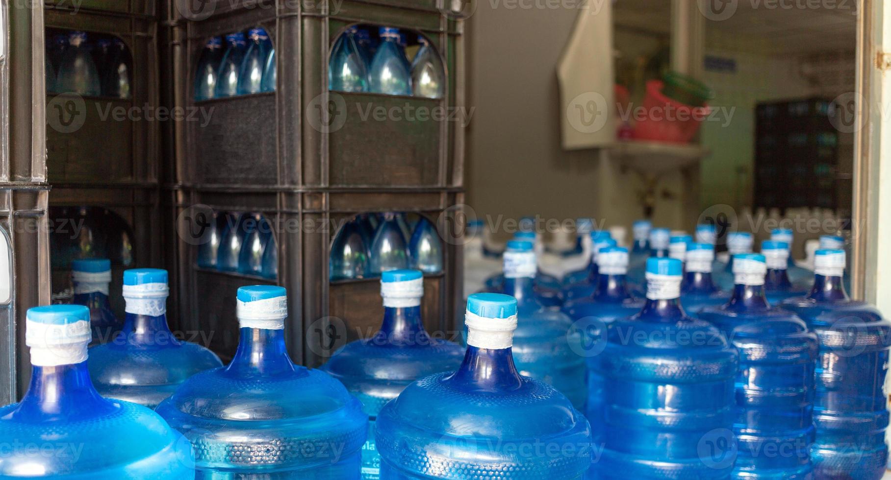 de blå vatten gallon som innehåller dricka vatten har varit sluten med en plast täta i de dricka vatten växt till vänta för leverans foto