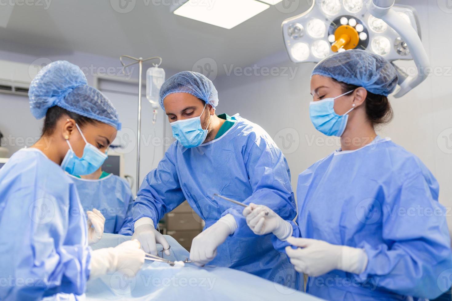 brådskande kirurgi. professionell smart intelligent kirurger stående nära de patient och utför ett drift medan sparande hans liv foto
