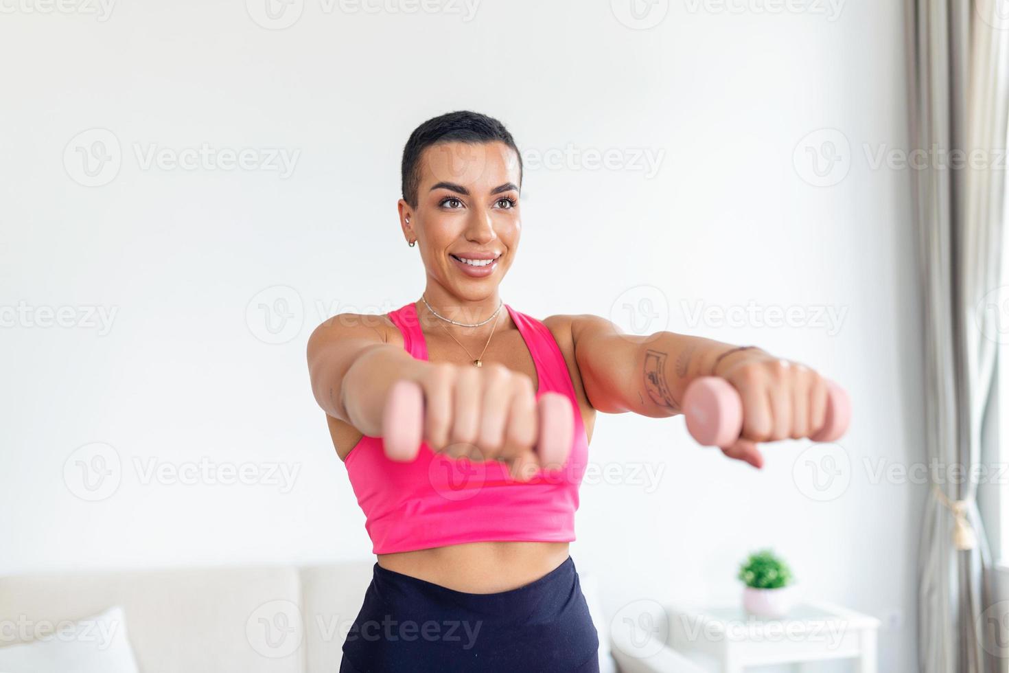 inhemsk Träning med vikter. positiv svart lady håller på med övningar med hantlar, förstärkning henne kropp på Hem. leende ung kvinna arbetssätt på henne biceps muskler, vistas friska foto