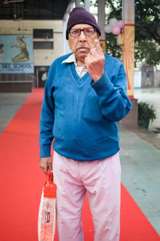 ny delhi, Indien - april 04 2023 - oidentifierad människor som visar deras bläckmärkt fingrar efter gjutning röster i främre av polling bås av öst delhi område för mcd lokal- kropp val 2022 foto