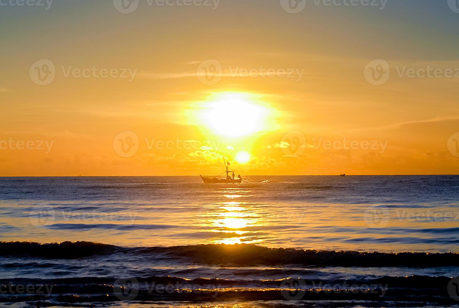 solnedgång över havet på kvällen, båt seglar på havet foto