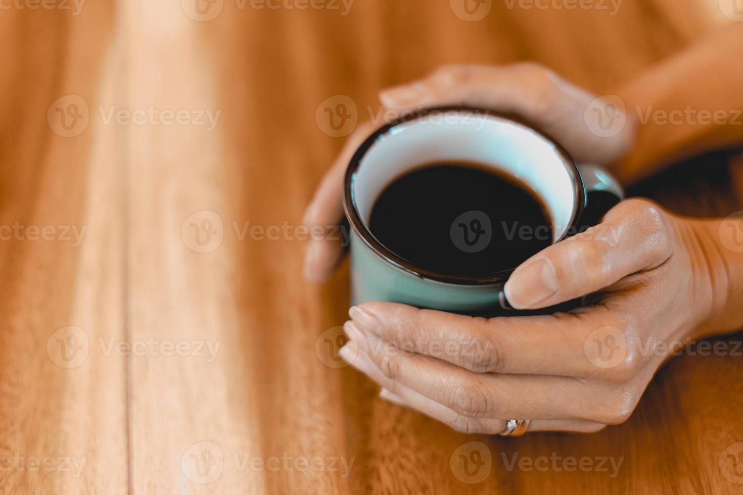 kopp bryggt svart kaffe på träbordet foto