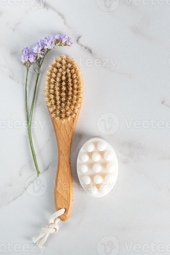 topp se av spa behandlingar, masse tvål och torr massage borsta med dekoration av blommor foto
