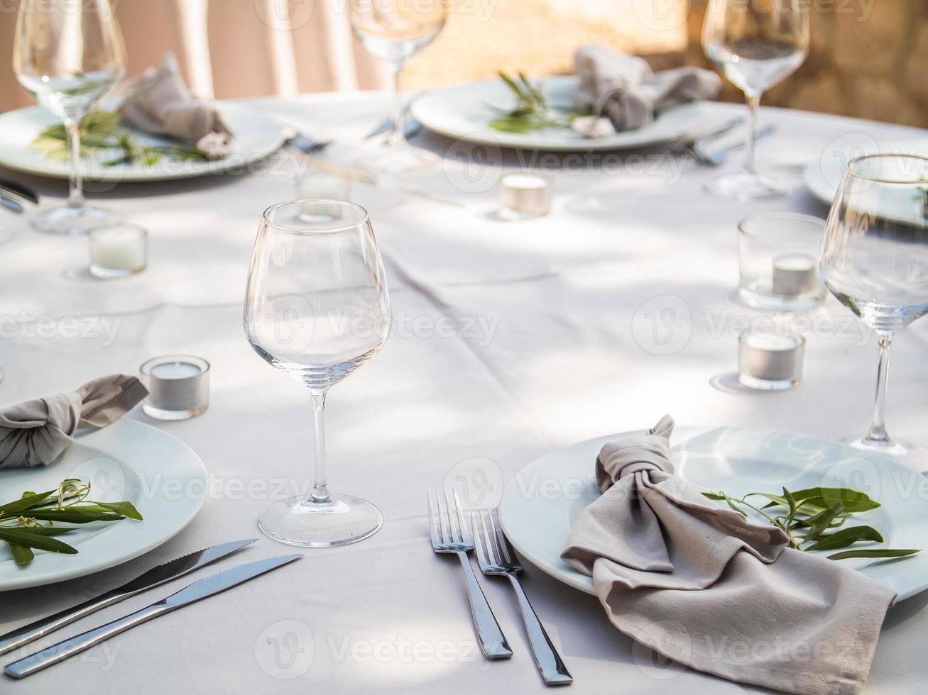 tabell på lyx bröllop reception händelse. skön blommor på tabell och tjänande maträtter och glasögon och dekoration foto