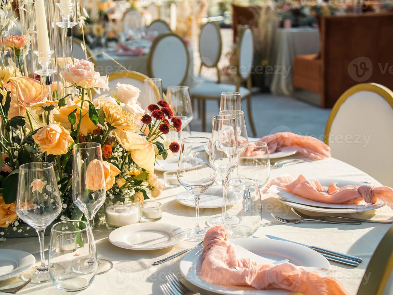 skön utomhus- bröllop dekoration i stad. ljus och torkades blommor och Tillbehör med buketter och glasögon på tabell med Linné bordsduk på nygifta tabell på grön gräsmatta foto