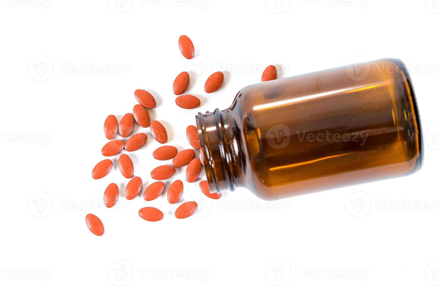 en hel del piller och medicin som häller från flaskan på vit bakgrund foto