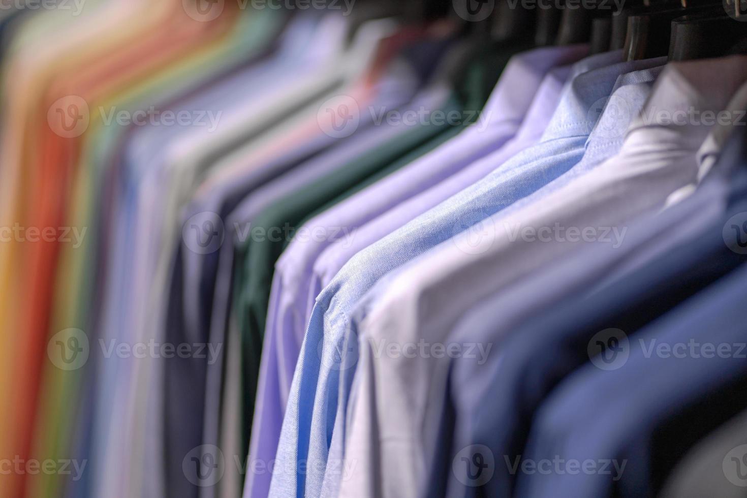 närbild av flerfärgade skjortor på galgar foto