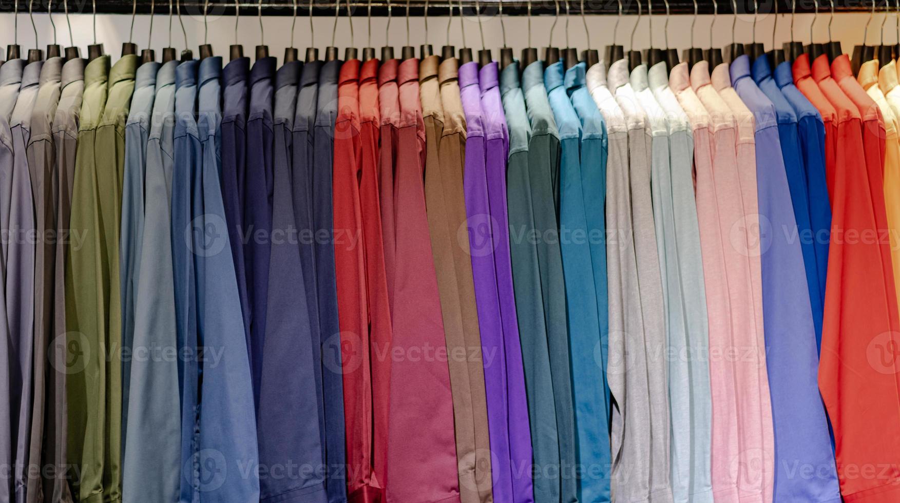 närbild av flerfärgade skjortor på galgar foto