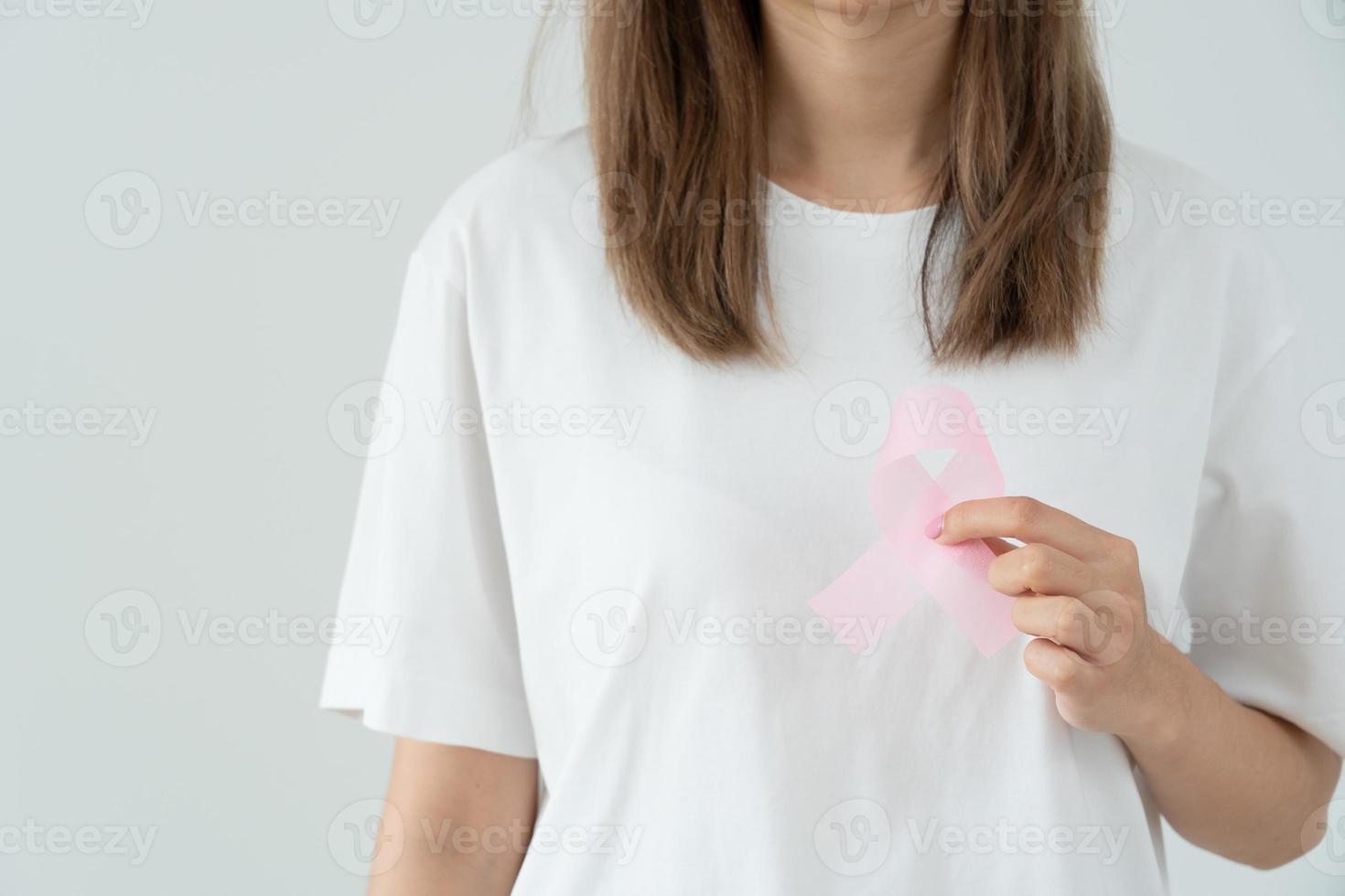 kvinna håll rosa band bröst cancer medvetenhet. kvinna hälsa kolla upp medvetande. internationell kvinnor dag och värld cancer dag. tecken cancer, symbolisk, hälsa vård, Stöd patienter, i god tid diagnos foto