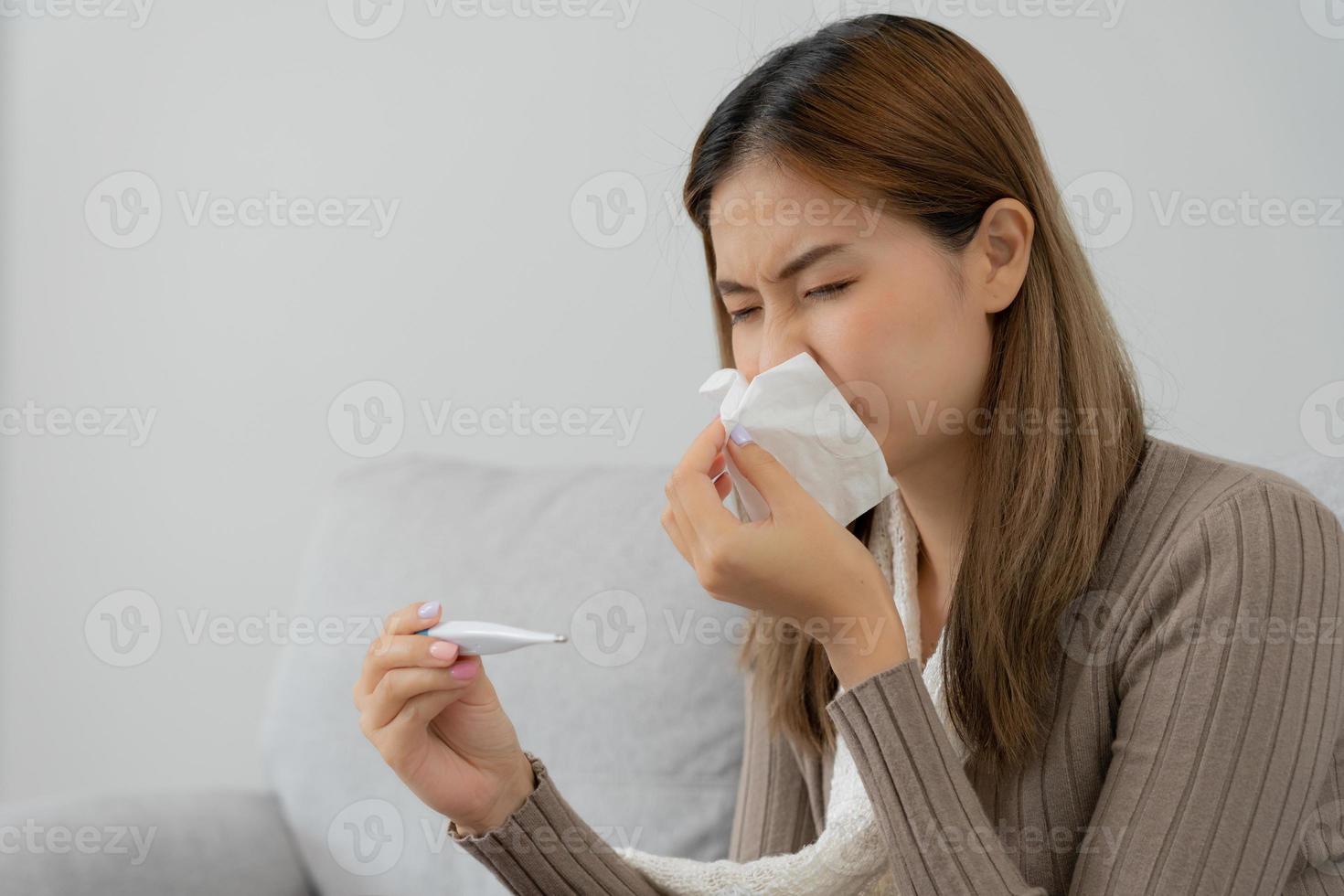 ung asiatisk kvinna har hög feber medan kontroll kropp temperatur, kvinna nysning och rinnande näsa med säsong- influensa, allergisk, digital termometer, virus, coronavirus, sjukdom, respiratorisk foto