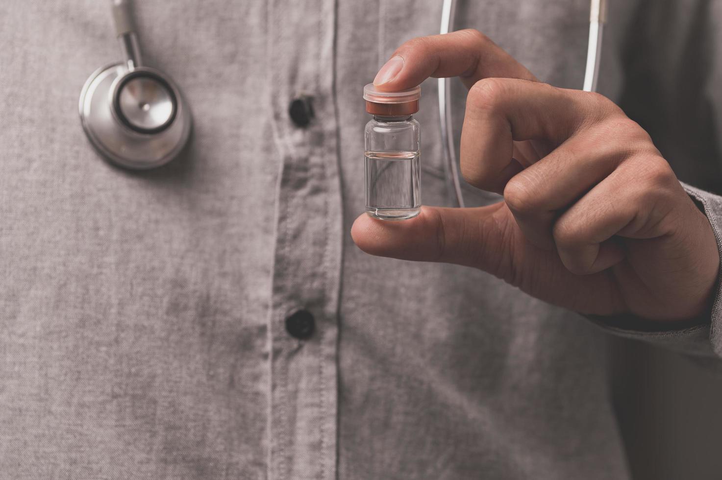 läkaren har en vaccinflaska för att döda sjukdomen foto
