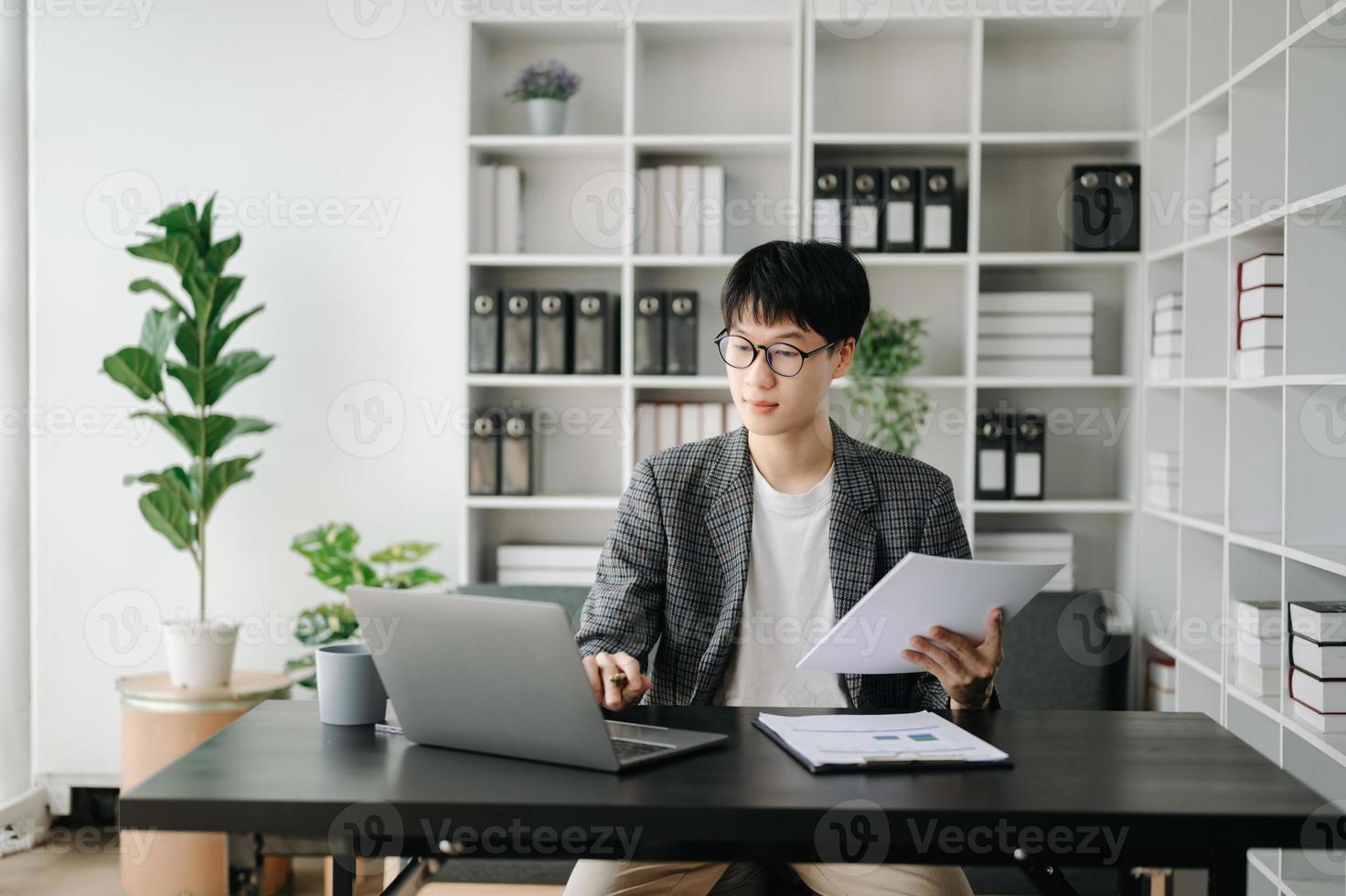 ung företag man verkställande chef ser på bärbar dator tittar på uppkopplad webinar Träning eller har virtuell möte video konferens håller på med marknadsföra forskning arbetssätt i kontor. foto