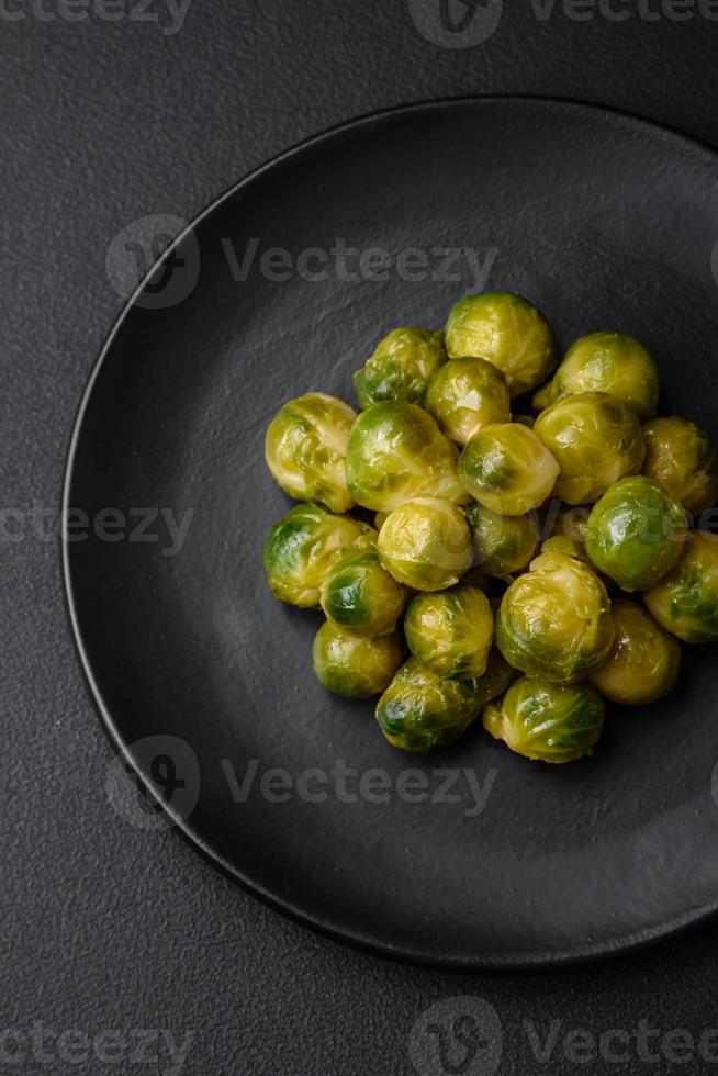 utsökt kokt bryssel groddar på en keramisk tallrik på en mörk betong bakgrund foto