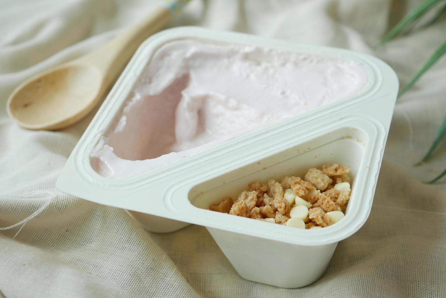 färsk yoghurt i en plastbehållare och sked på bordet foto