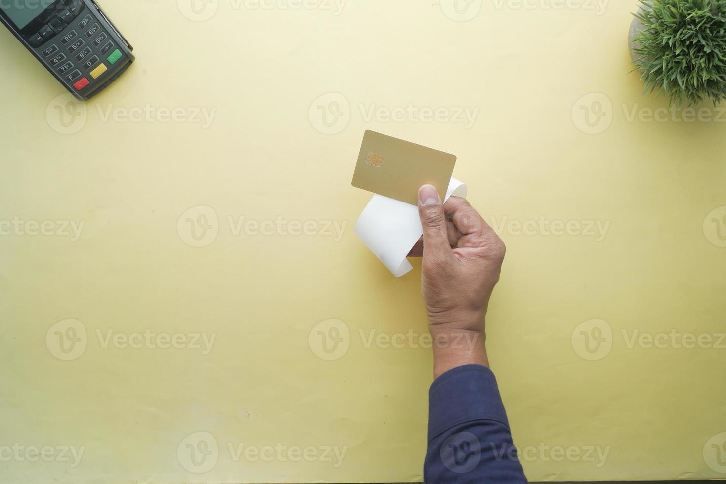 topp se av person hand innehav kreditera kort och en försäljning mottagande foto