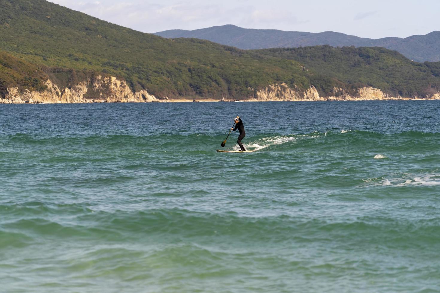 marinmålning med en sap-surfare på ett bräde. primorsky krai foto