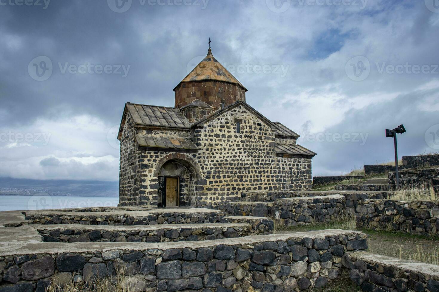 kloster under dramatisk vår himmel Foto. gammal kyrka nära sjö sevan begrepp Foto. hög kvalitet bild för tapet foto