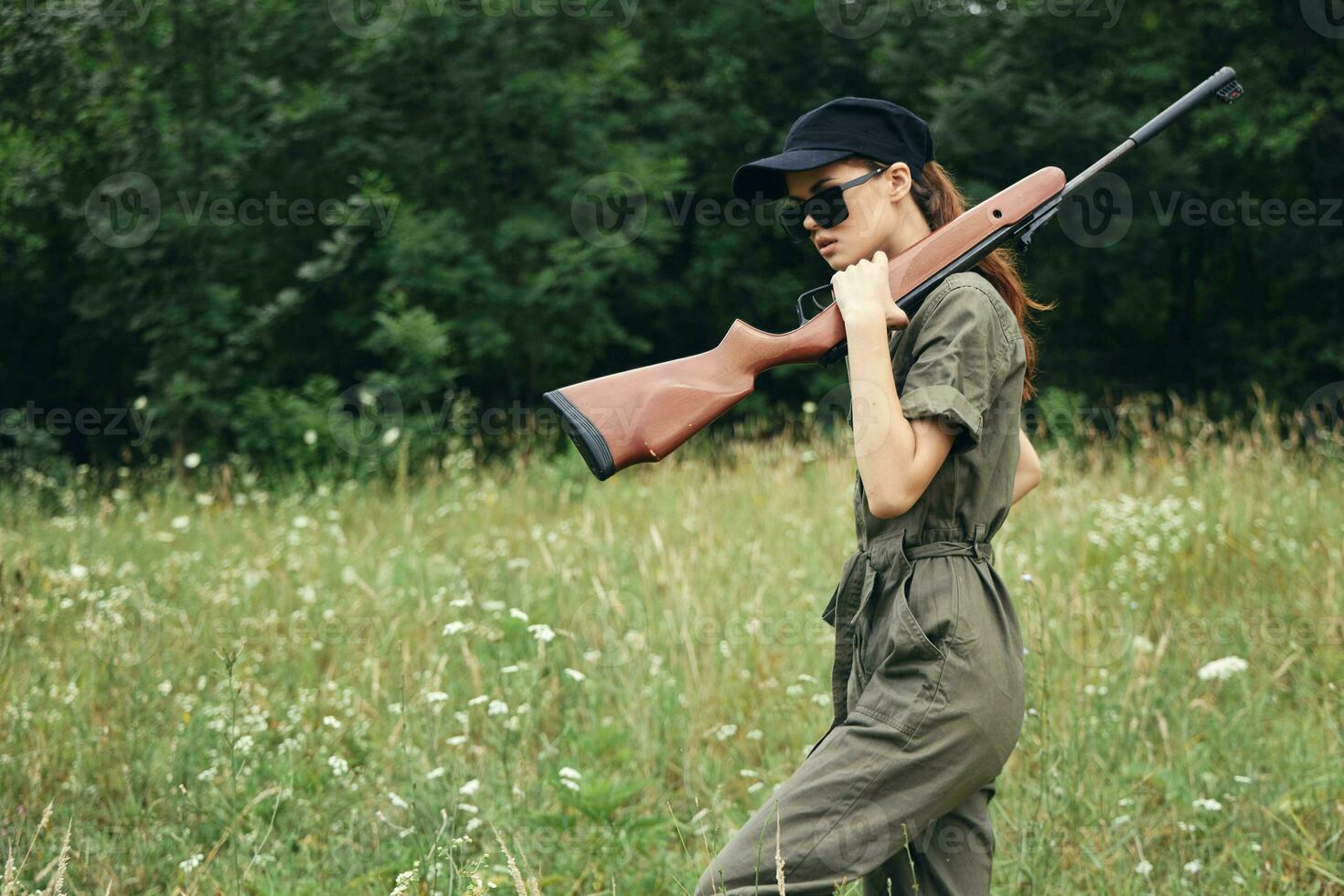 kvinna på utomhus- i solglasögon med en pistol jakt resa foto