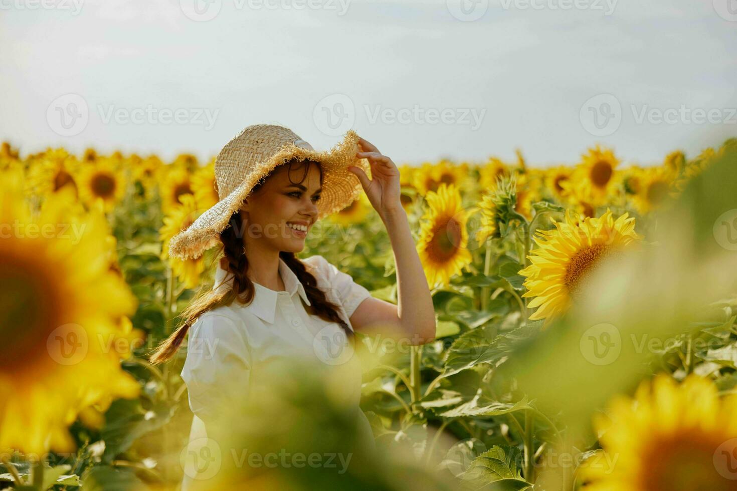 kvinna med pigtails i en hatt på en fält av solrosor landskap foto